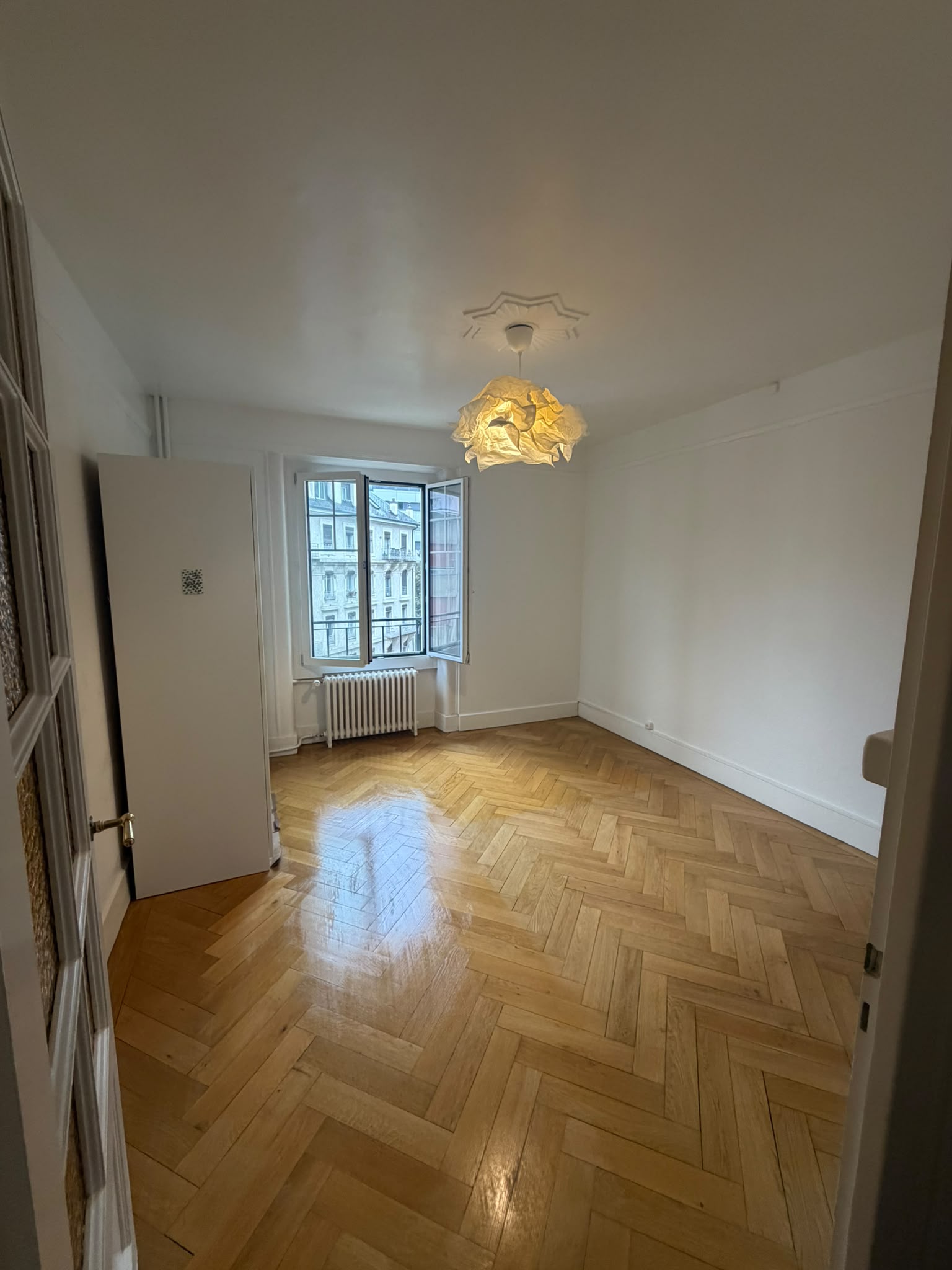 Après : la chambre repeinte en blanc, rosace restaurée, parquet à bâtons rompus remis en valeur