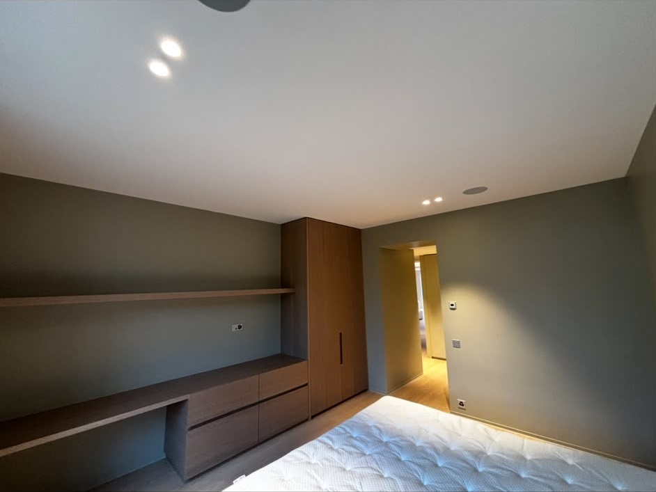 Chambre aux murs peints en vert-gris avec mobilier en chêne sur mesure