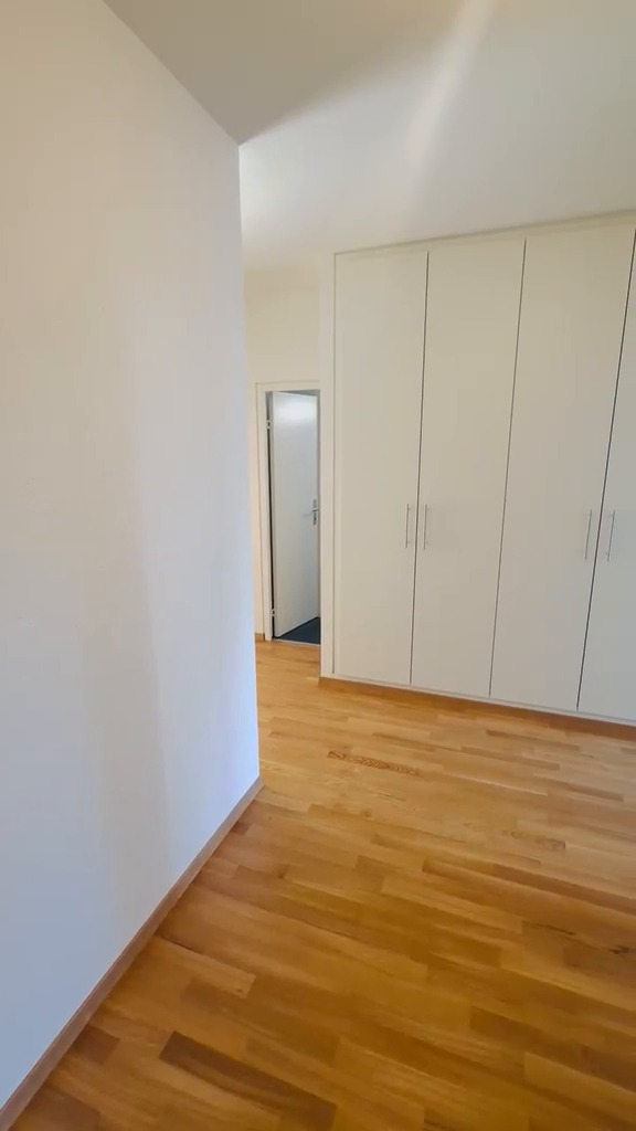 Entrée d’appartement livrée : armoires encastrées et murs peints en blanc, parquet en chêne